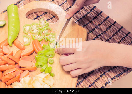 Preparazione di una stir fry di legumi stufati e salsiccia Foto Stock