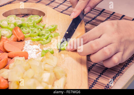 Preparazione di una stir fry di legumi stufati e salsiccia Foto Stock