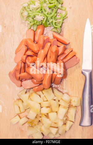 Preparazione di una stir fry di legumi stufati e salsiccia Foto Stock