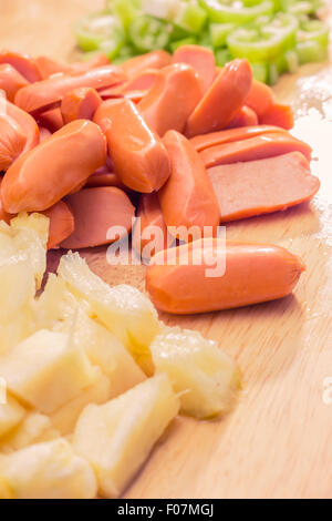 Preparazione di una stir fry di legumi stufati e salsiccia Foto Stock