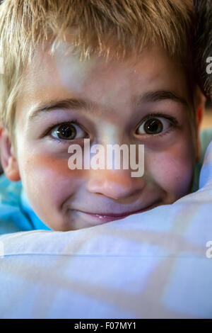 Sette anni di vecchio ragazzo peeking oltre la spalla di suo nonno e di una finestra con la riflessione su di essi, a Seattle, Washington, Stati Uniti d'America Foto Stock