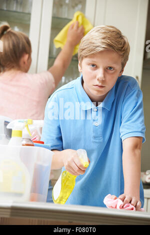 Infelici i bambini aiutano a pulire la casa Foto Stock