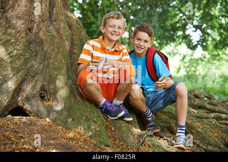 Due ragazzi di utilizzare il metodo geocaching in bosco Foto Stock