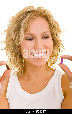 Felice giovane donna confrontando due diversi farmaci Foto Stock