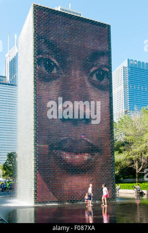 Bambini che giocano nella corona Fontana nel Millennium Park di Chicago. Foto Stock