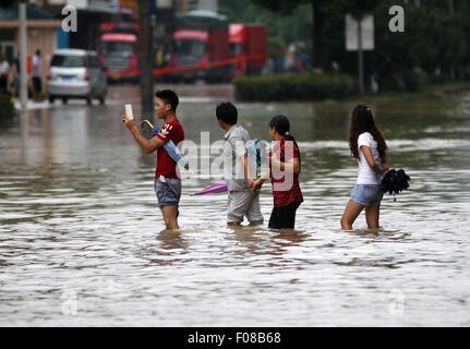 Taizhou, cinese della Provincia di Zhejiang. 10 Ago, 2015. Persone wade attraverso acqua a Daxi sezione del National Highway 104 in Wenling, est della Cina di Provincia dello Zhejiang, il 10 agosto 2015. A causa delle pesanti piogge causate dal tifone Soudelor dal 9 agosto al 10 agosto, sezione locale del National Highway 104 era saturo di acqua e il traffico è stato interrotto. Il traffico è stato ripreso lunedì mattina. Credito: Zhou Xuejun/Xinhua/Alamy Live News Foto Stock