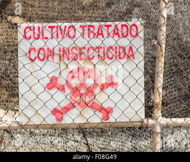Sign in spagnolo sulla fattoria in Spagna dicendo coltura trattata con insetticida ( cultivo tratado con insecticida ). Foto Stock