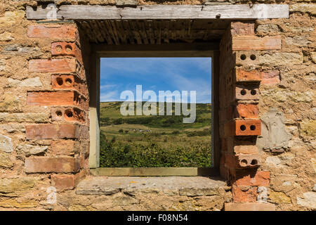 Nella campagna del Dorset attraverso la finestra del giardiniere in casa il villaggio fantasma di Tyneham, Dorset, Inghilterra Foto Stock