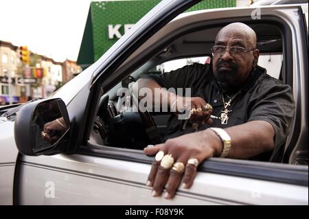 Uomo calvo che indossa gioielli in oro seduti in auto, New York, Stati Uniti d'America Foto Stock