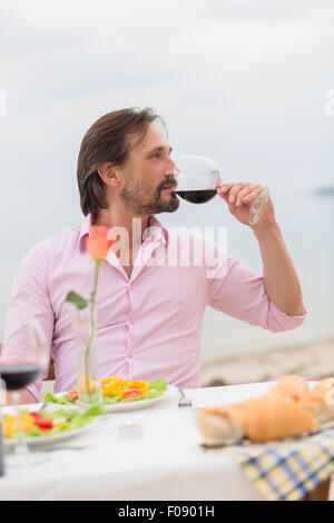 Uomo bello bere un vino Foto Stock