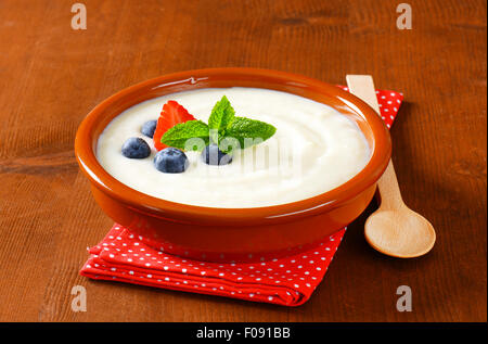 La semola liscia porridge servito nel piatto di terracotta con frutta fresca Foto Stock