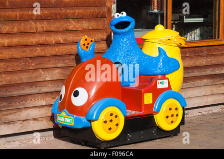 Sesame Street caratteri bambini's ride al di fuori del negozio a Trentham Shopping Village Foto Stock