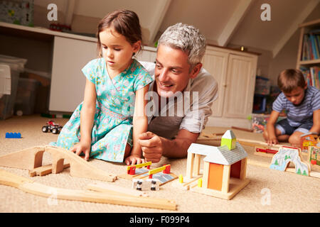 Padre a giocare con i bambini e giocattoli in un attico sala giochi Foto Stock