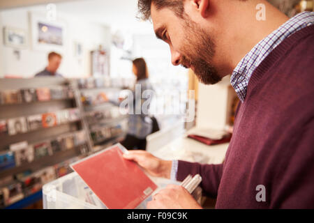 L'uomo l'ordinamento di record in un negozio di record Foto Stock