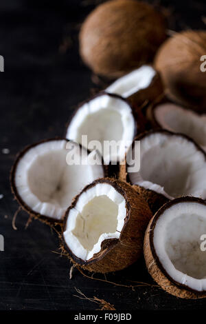 Fresh incrinato noci di cocco vengono visualizzate su uno sfondo scuro Foto Stock