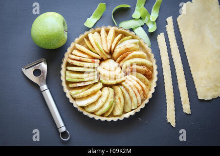 Tart piatto a base di pasta e ripieno di mele prima della cottura.vista superiore Foto Stock