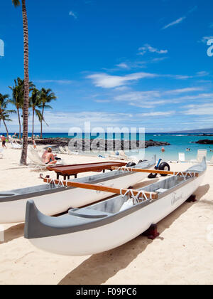 Una vista di una canoa outrigger sulla spiaggia di sabbia bianca della baia di Pauoa presso il Fairmont Orchid sulla Costa Kohala, Hawai'i (Hawaii). Foto Stock