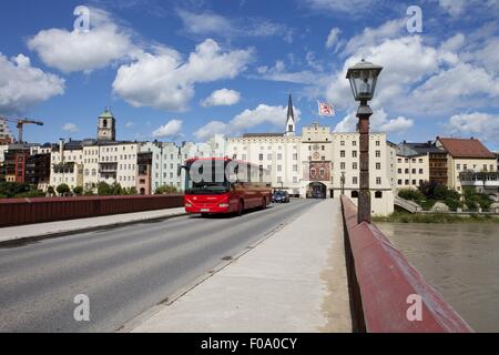 Donna che cammina sulla strada di fronte a Wasserburg am Inn in Rosenheim, Baviera, Germania Foto Stock