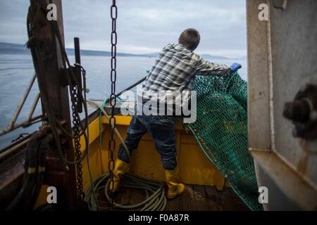 Fisherman preparazione net, Isola di Skye in Scozia Foto Stock