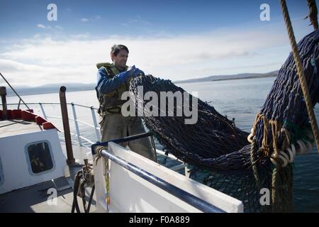 Fisherman preparazione net, Isola di Skye in Scozia Foto Stock