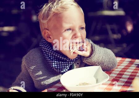 Carino ragazzo di mangiare toast in cucina Foto Stock