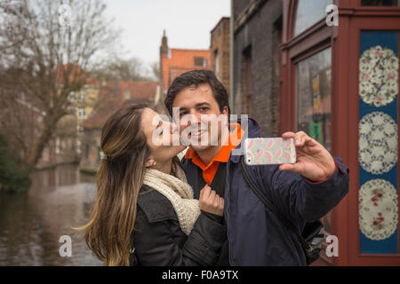 Giovane tenendo selfie sullo smartphone, Bruges, Fiandre, in Belgio Foto Stock