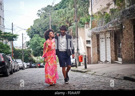 Paio di camminare per strada di ciottoli, sorridente Foto Stock