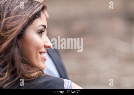 Coppia giovane assieme, all'aperto, guardando lontano, sorridente Foto Stock