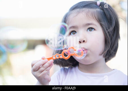 Ragazza giovane soffiare bolle, close-up Foto Stock