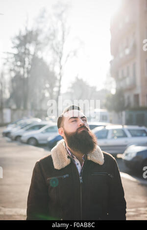 Giovane uomo barbuto su strada Foto Stock