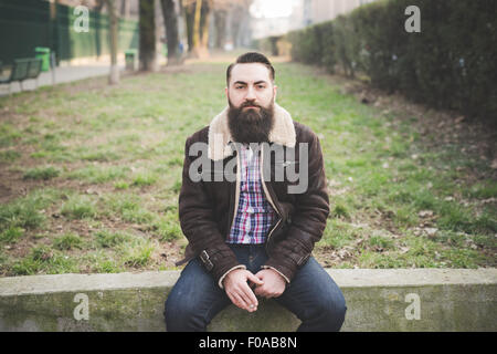 Giovane uomo barbuto in posizione di parcheggio Foto Stock
