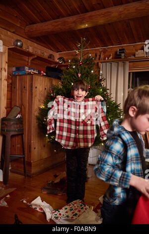 Ragazzo gioioso mantenendo la maglietta di Natale Foto Stock