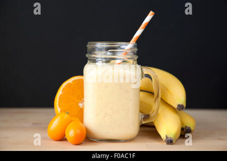 Ancora in vita di banane fresche, arancione e kumquat smoothie Foto Stock