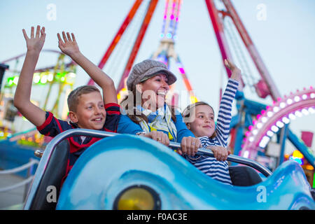 Donna matura con il figlio e la figlia sulla fiera ride Foto Stock