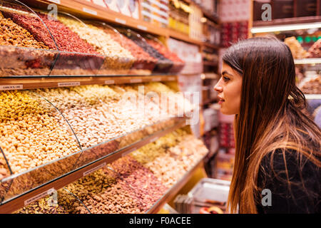 Giovane donna guardando gli alimenti nel mercato, Istanbul, Turchia Foto Stock