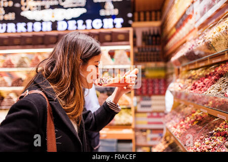 Giovane donna odore di cibo nel mercato, Istanbul, Turchia Foto Stock