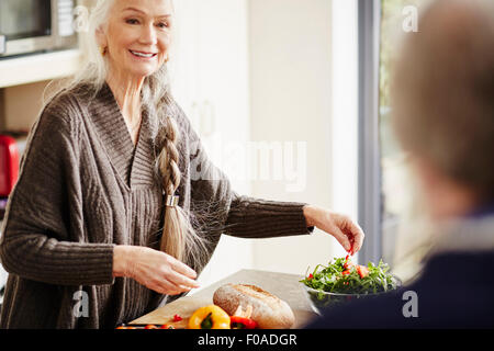 Donna senior di preparare il cibo in cucina Foto Stock