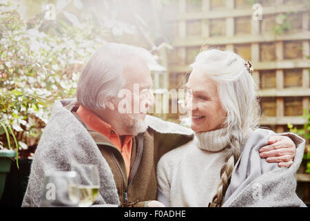 Coppia senior avvolto in una coperta in giardino Foto Stock