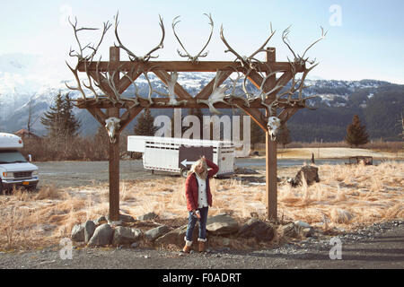 Donna da parte di arcata con teschi di animali, Girdwood, Anchorage in Alaska, Foto Stock