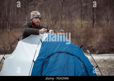 Metà uomo adulto mettendo a tenda Foto Stock