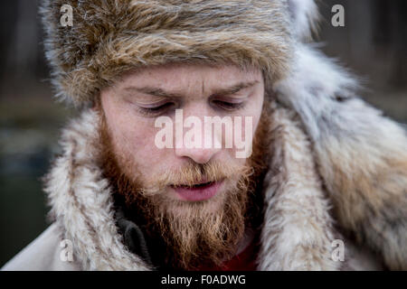 Metà uomo adulto che indossa trapper hat, ritratto Foto Stock