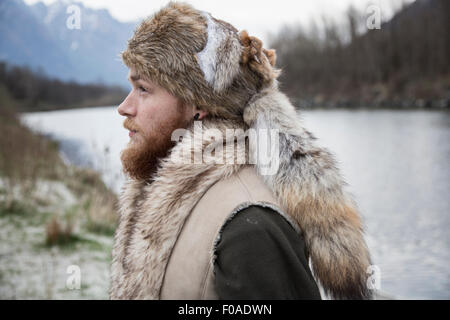 Metà uomo adulto che indossa trapper hat, ritratto Foto Stock