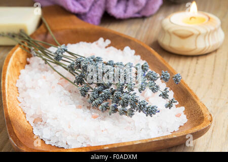 Spa ancora vita Impostazione con sale marino e fiori di lavanda in un piatto di legno Foto Stock