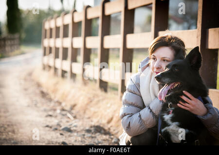 Ritratto di metà donna adulta con il suo cane sul vicolo del paese Foto Stock