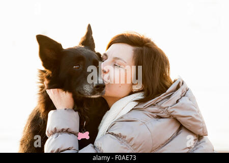 In prossimità di metà donna adulta baciare il suo cane Foto Stock