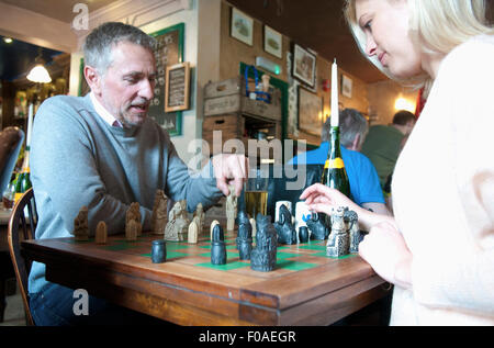 Giovane giocando a scacchi in pub Foto Stock