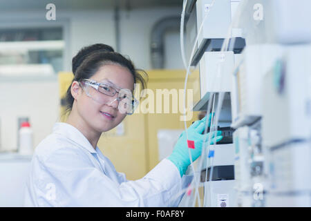 Ritratto di giovane donna scienziato utilizzando apparecchiature scientifiche in laboratorio Foto Stock