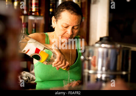 Donna che serve liquori in bar Foto Stock