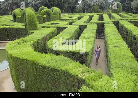 Donna in corsa tra laberint in Barcellona, Spagna Foto Stock