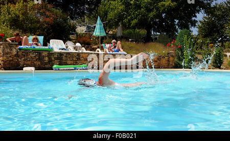 Giovane donna in vacanza piscina crawl anteriore in una piscina da una gite a Frayssinet-le-Gelat nel sacco Regione Dipartimento della Francia Foto Stock